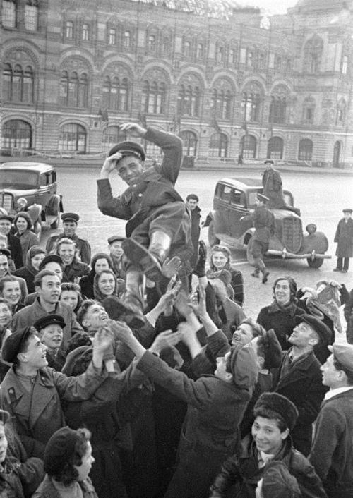 Moskvalılar Qırmızı meydanda qələbə günü münasibətilə zabiti atıb tuturlar. Moskva, 9 may 1945-ci il