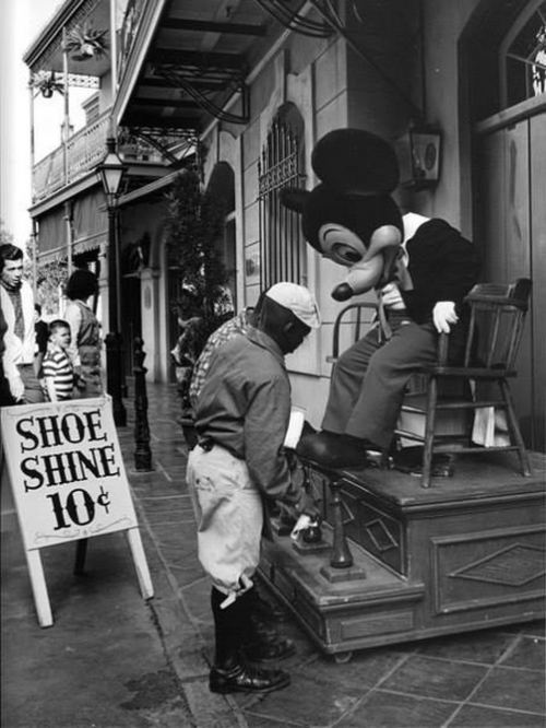 Mikki Maus kostyumunda olan aktyor Nyu-Orleandakı meydanda ayaqqabısını təmizlətdirir, ABŞ, 1969-cu il